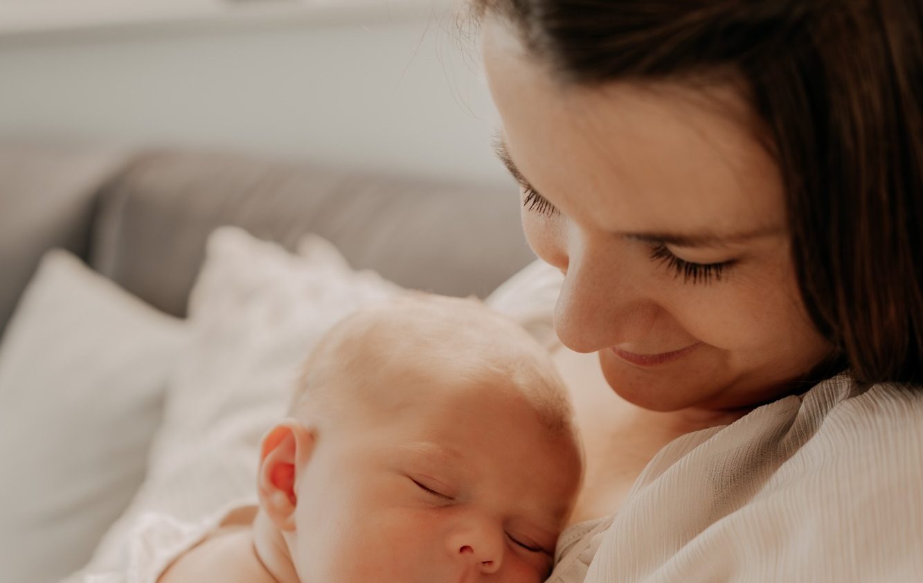 Bindungsorientierte Mutter hält ihr schlafendes Baby liebevoll im Arm