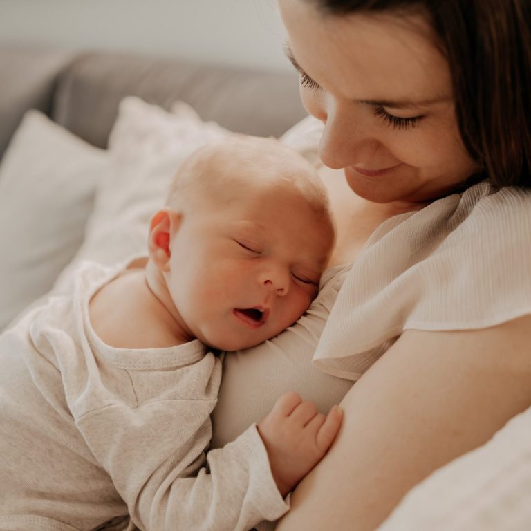 Bindungsorientierte Mutter hält ihr schlafendes Baby liebevoll im Arm